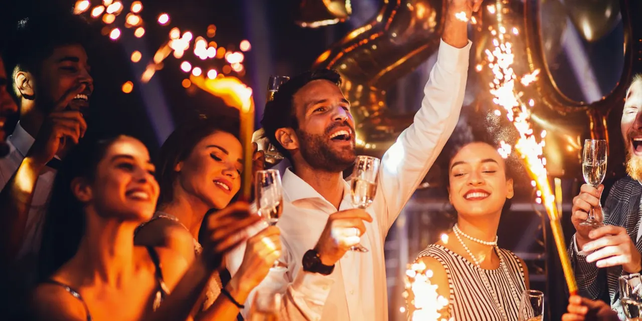 Feiernde Gäste mit Wunderkerzen auf einer Geburtstagsparty